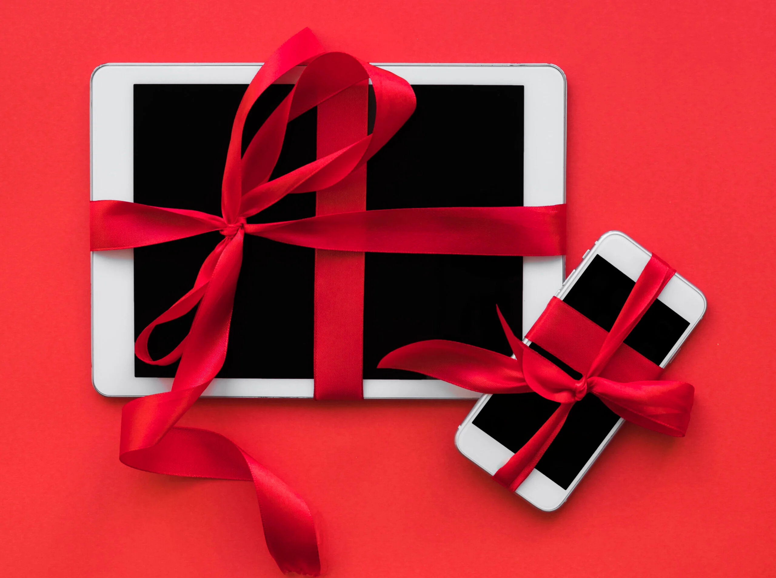 A mobile phone and tablet packed like a gift, representing the extra warranty benefits of choosing the best credit card for mobile purchase in India.